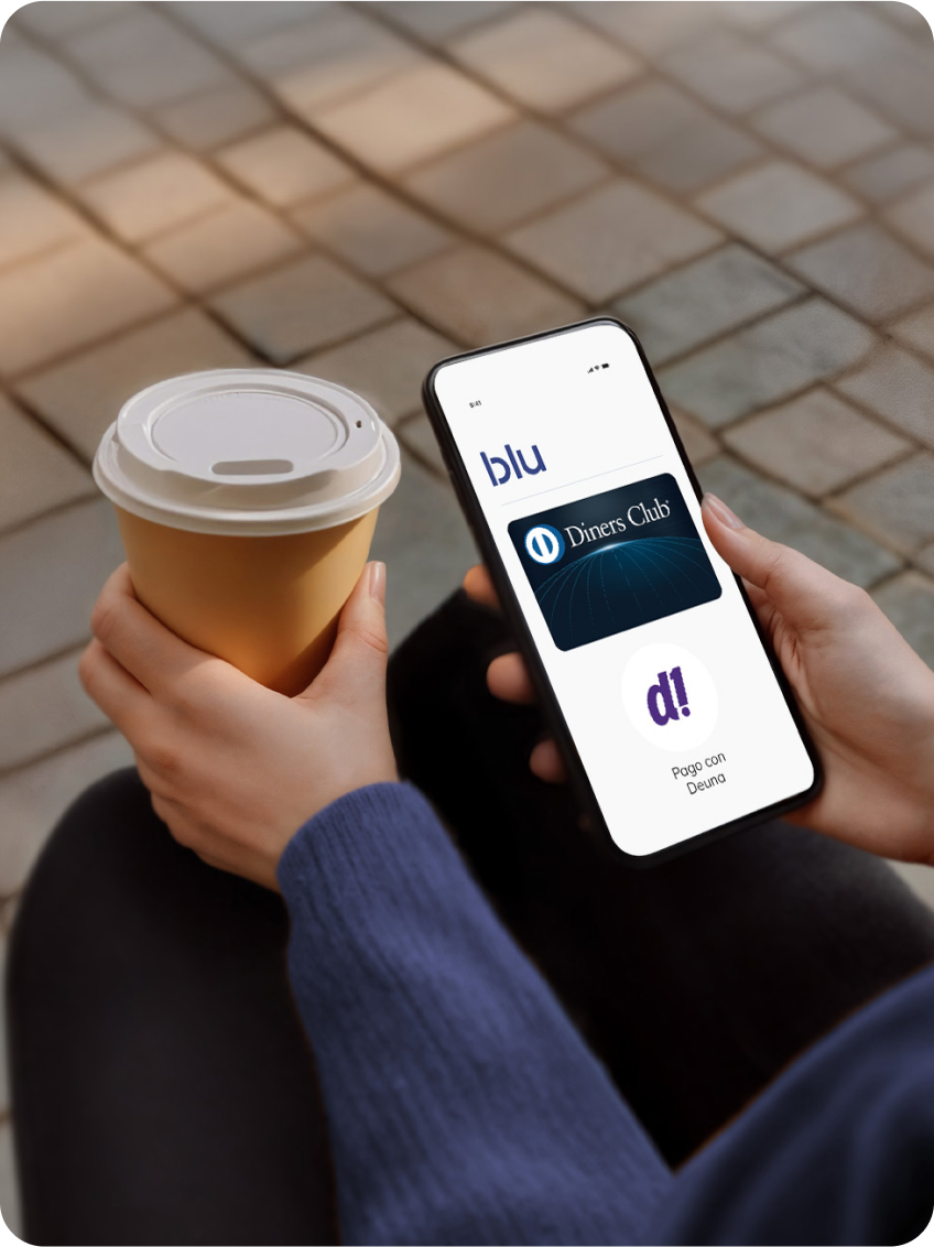 Detalle de una persona sosteniendo un teléfono y un café