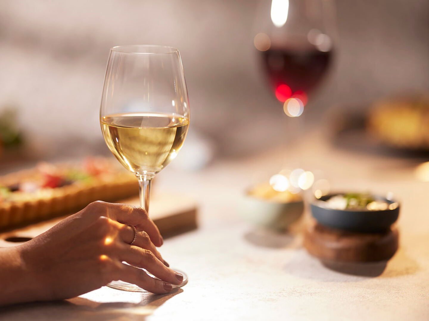 Persona disfrutando de los beneficios del vino blanco junto con una copa de Diners Collection
