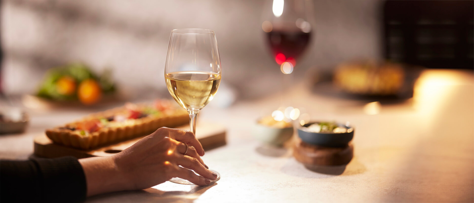 Persona disfrutando de los beneficios del vino blanco junto con una copa de Diners Collection