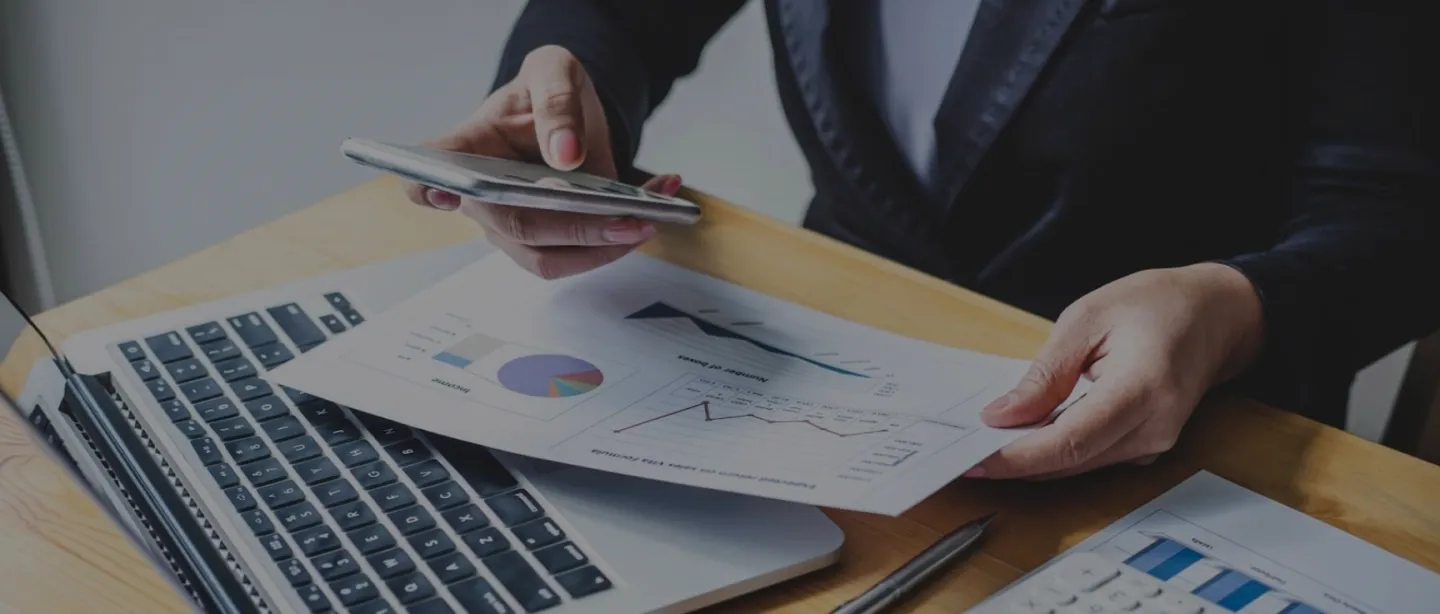 Detalle de persona con celular mirando reportes