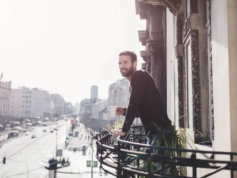 Titanium Visa Platinum: Un hombre mirando la ciudad desde su balcón