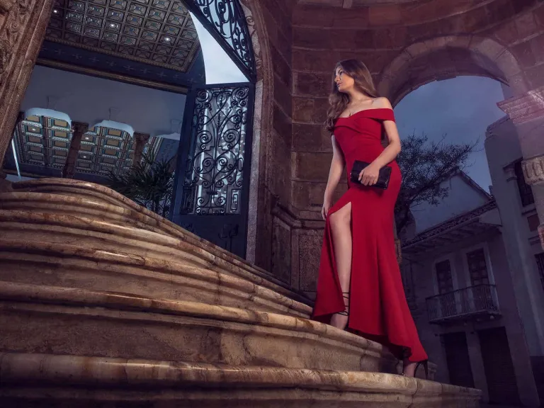 Una mujer vestida de rojo subiendo unas escaleras de piedra 