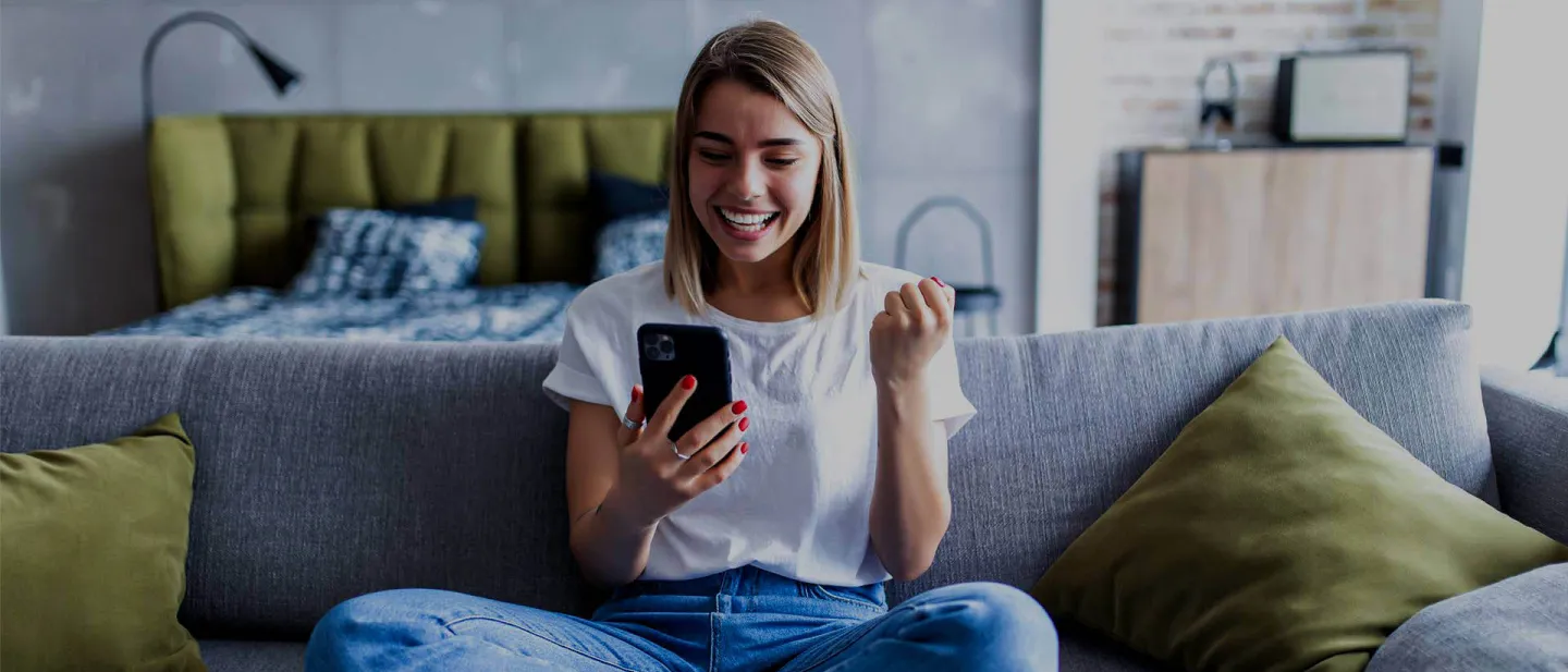 Chica sentada con celular sonriendo