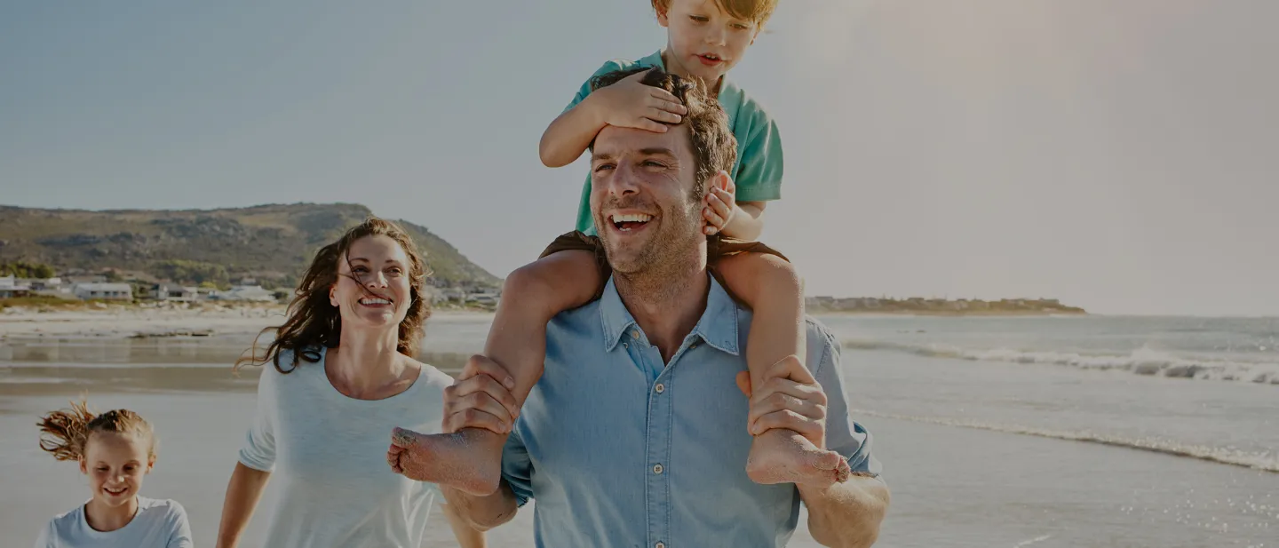 Viajes Diners Club International: Familia sonrientes en la playa