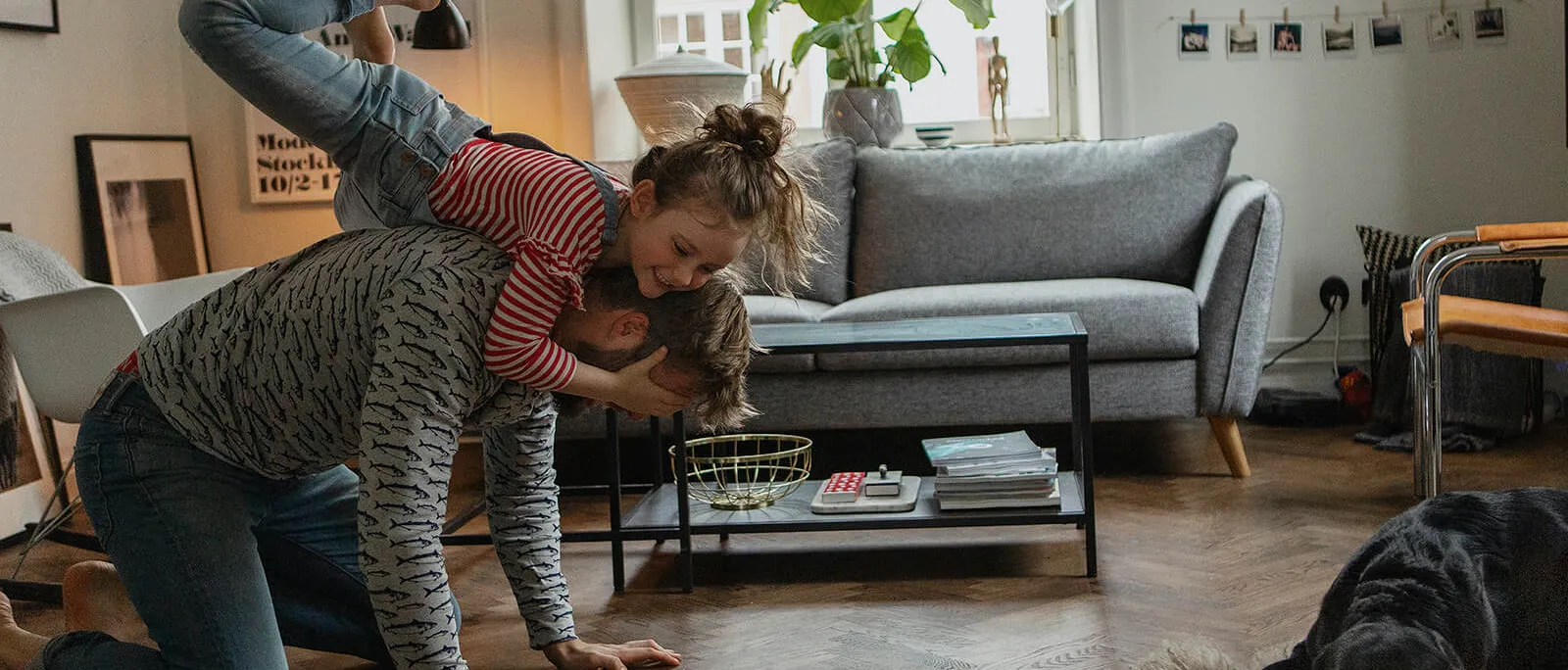 Seguros Diners Club: Una niña jugando con su padre en la sala de su casa 