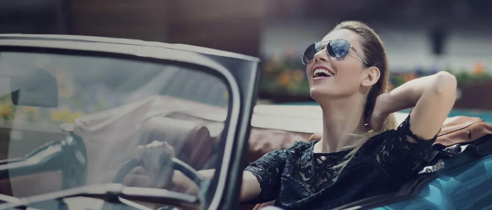 Una chica manejando muy feliz por su titanium mastercard black