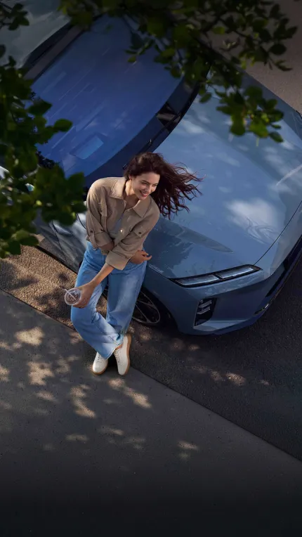 Mujer joven recostada a un auto