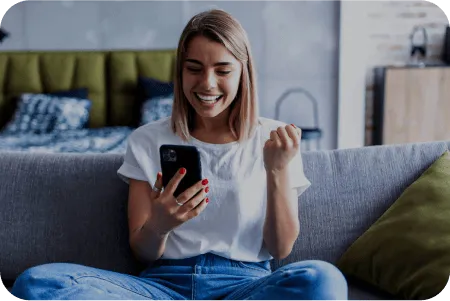 Mujer joven sonriendo con el móvil en la mano