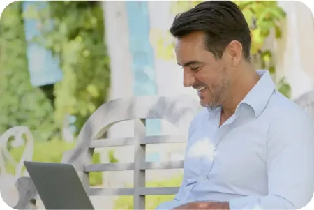 Hombre con una computadoras sonriendo