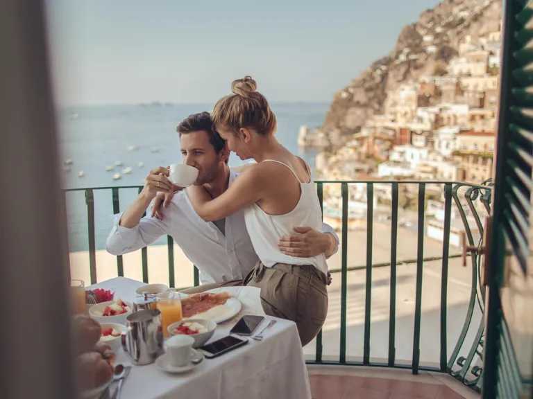 Pareja sentada de vacaciones desayunando